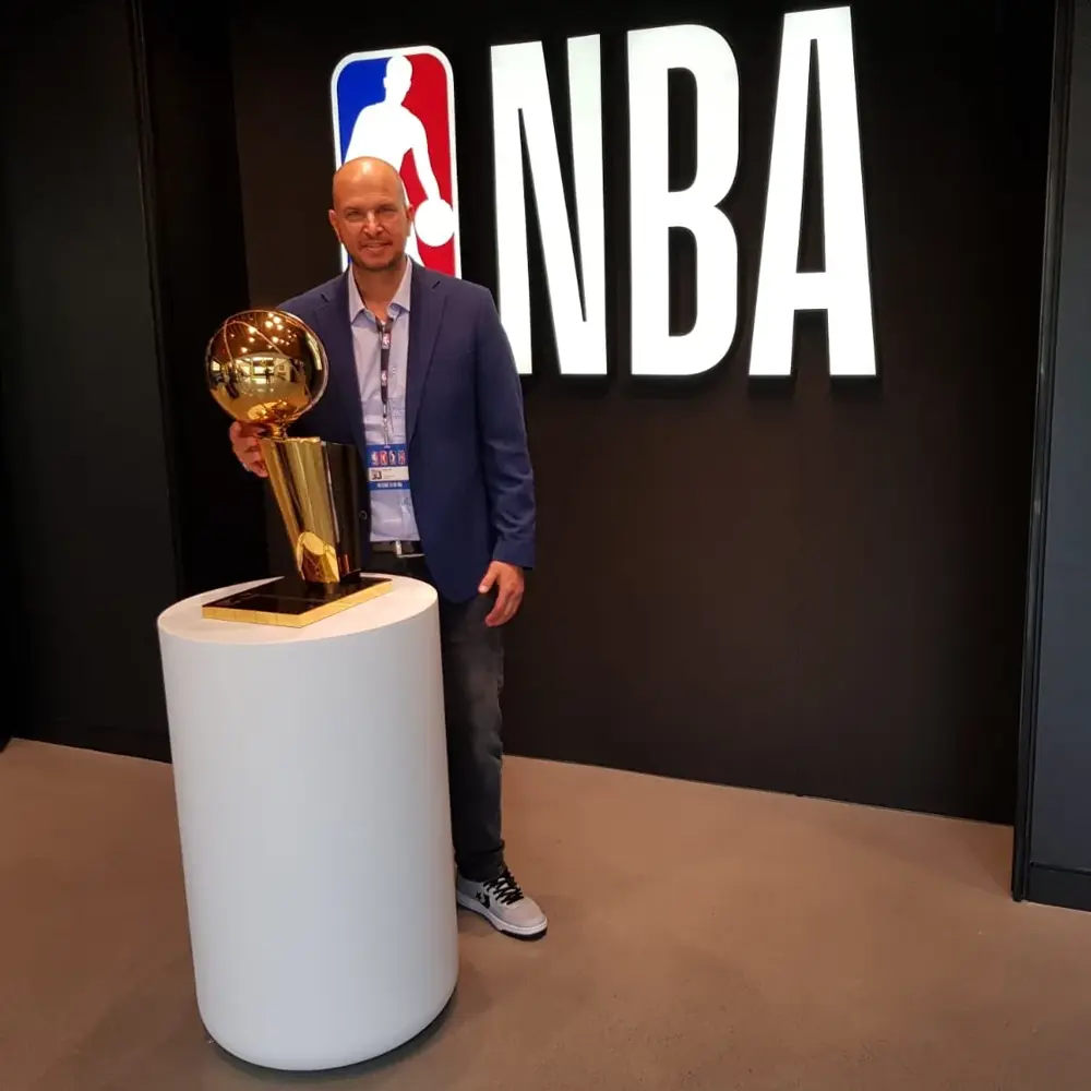 Tamir Kfir holding the NBA championship trophy at the NBA offices